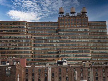 Çatısı Çatı Tankları olan Şehir Ofisi Binası - Yeşil camlı ve çatısı ikonik üç su tankı olan New York City ticari binası.