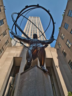 Rockefeller Center 'daki Atlas Heykeli - Beşinci Cadde' deki gökyüzü küresinin arkasında Rockefeller Center binası bulunan ikonik bronz heykel.