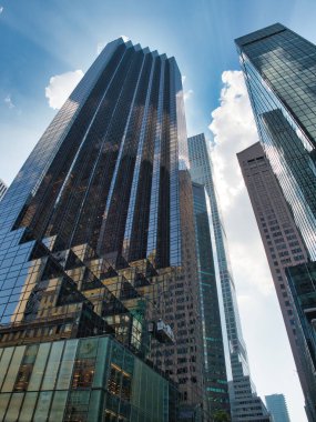 Alttan modern Manhattan Gökdelenleri - New York şehrinde yansıtıcı cam cepheli, gösterişsiz, modern gökdelenlerin düşük açılı görüntüsü, güçlü bir kentsel perspektif yaratıyor..