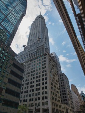 Chrysler Binası ve Midtown Gökdelenleri - New York 'taki ikonik Chrysler Binası' nın dramatik alçak açılı görüntüsü, Manhattan şehir merkezindeki modern binalar tarafından çerçevelenmiştir..