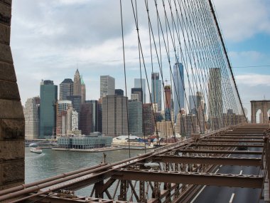 Brooklyn Köprüsü ve Aşağı Manhattan Skyline - Brooklyn Köprüsü 'nden görünen aşağı Manhattan silueti yolu, köprü yapısını ve mavi bulutlu gökdelenleri gösteriyor.