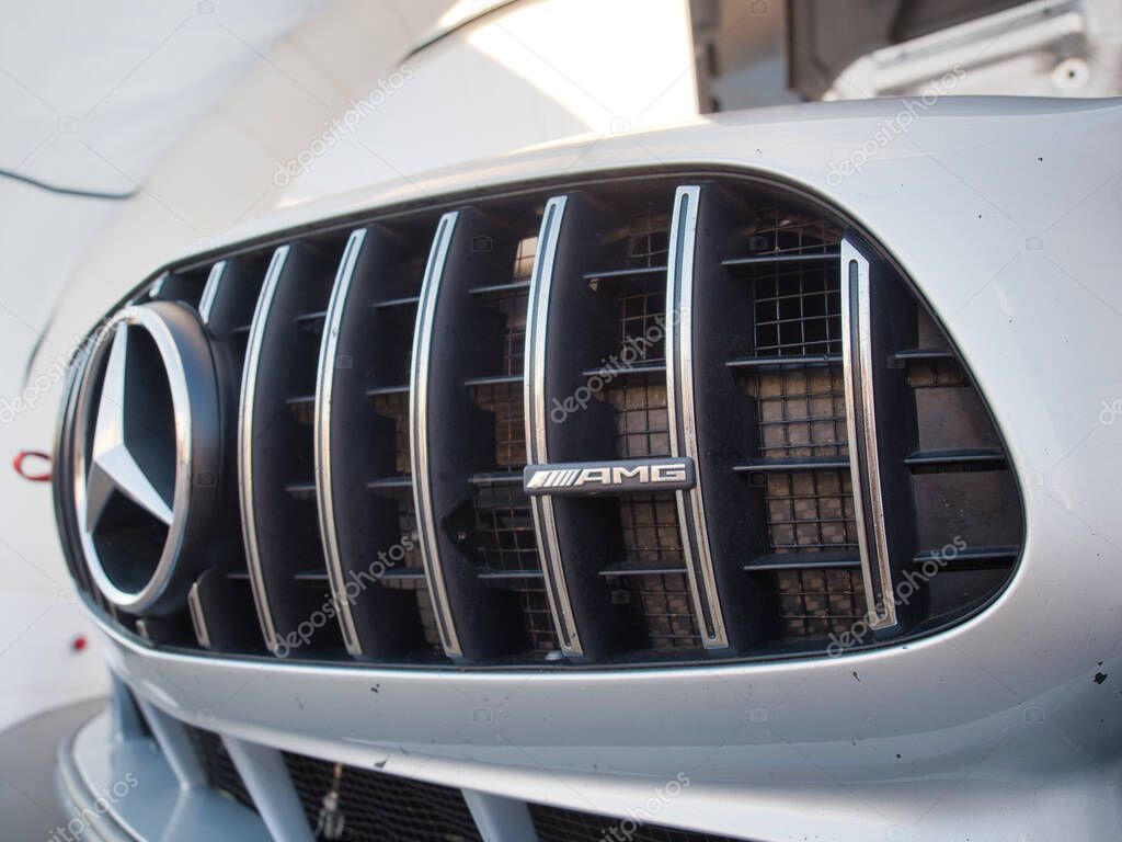 Mercedes-AMG Grille Close-up - Luxury Car Detail - A detailed, low-angle shot of a Mercedes-AMG sports car's front grille, highlighting its logo and the precision of its design.