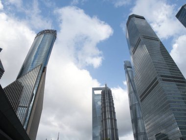 Şanghay Finansal Gökdelenleri - Şangay 'ın finansal bölgesindeki modern gökdelenlerin dramatik alçak açılı çekimi, eşsiz mimari tasarımları ve yansıtıcı cam cepheleri dinamik bulutlu ve mavi gökyüzüne doğru uzanıyor..