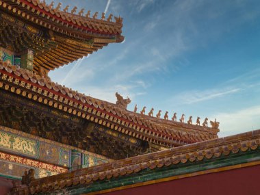 Yasak Şehir 'deki bir binanın dekoratif ve renkli bir çatısı, açık mavi gökyüzü, geleneksel Çin mimarisi ve mitolojik figürlerinin karmaşık detaylarını gözler önüne seriyor..