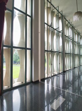 Vietnamlı bir hükümet binasının modern koridoru - yansıtıcı zemini olan uzun, parlak bir koridor, soyut desenli geniş pencereler, ve sütunlar, parlak ve modern bir mimari iç mekan yaratıyor..