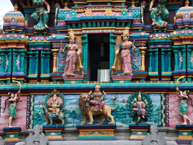 Hindu tapınağı cephesindeki karmaşık heykeller, bir Hindu tapınağının dışındaki süslü heykellerin ve dekoratif figürlerin canlı ve detaylı bir yakın çekimi..