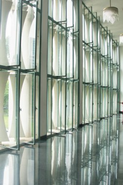 Soyut tasarımı olan modern cam pencereler - Parlak bir zeminden yansıyan, tekrarlanan kavis şeklindeki soyut tasarımın yer aldığı, uzun bir sıra modern cam pencereli koridor.