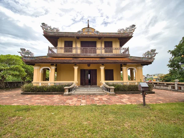 Hue 'da geleneksel mimarisi olan kraliyet sarayı - iki katlı bir kraliyet binası sarı cepheli, balkonlu ve geleneksel çatı süslemeleri olan, çimenlik ve fayanslı yollarla çevrili.