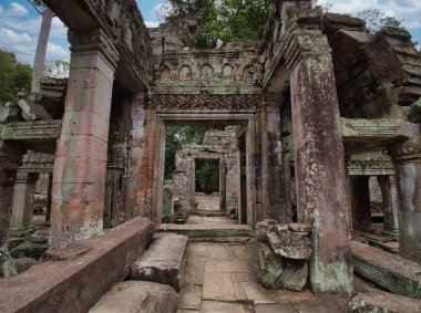 Angkor Tapınağı Koridoru 'nun yıkılması - Kamboçya' nın eski bir tapınağının çürüyen iç kısmı, oyulmuş sütunlar, çökmüş taşlar, ve harabelerin derinliklerine giden bir yol..