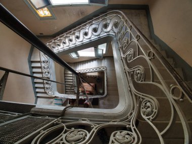 Binadaki tarihi sanat eseri yeni merdiveni eski bir binadaki karmaşık demiryolu ve klasik mimarisi olan güzel, eski bir spiral merdivenin yüksek açılı görüntüsü..