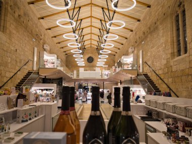 Şatafat ve parlak şarap dükkanı modern tasarımı olan eski bir taş binada ve şarap şişeleri sergilenen parlak bir iç mekan..