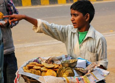 Agra, Hindistan - 8 Kasım: Tanımlanamayan çocuk Agra, Hindistan Taj Ganj mahallede chaat (Hint çerez) 8 Kasım 2014 satıyor. Agra Uttar Pradesh'ın en kalabalık şehirlerinden biridir