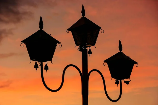 Silhouette of a lamp post at sunset at Sutaungpyei Pagoda on the top of Mandalay Hill, Mandalay, Myanmar. Mandalay Hill has been a major pilgrimage site for Burmese Buddhists for nearly two centuries