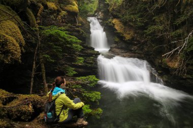 Sticta Falls Wells gri Provincial Park, British Columbia, Kanada tarafından oturan bir genç bayan. Dördüncü British Columbia'en büyük parkı olduğunu.