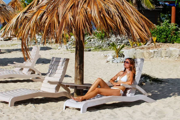 身穿比基尼的年轻女子躺在斐济南海岛的白色沙滩上的阳光椅上 — 图库照片