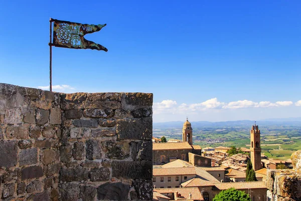 Metal flag on the top of Montalcino Fortress tower in Val d'Orcia, Tuscany, Italy. The fortress was built in 1361 atop the highest point of the town.