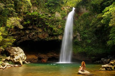 Genç kadın bikini alt Tavoro şelaleler Taveuni Island, Fiji Bouma ulusal miras Park'ta başına oturmuş. Taveuni Fiji'de üçüncü büyük adasıdır.