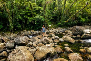 Genç kadın geçiş akışta bir iz Taveuni Island, Fiji Bouma ulusal miras Park'ta orta Tavoro şelaleler için