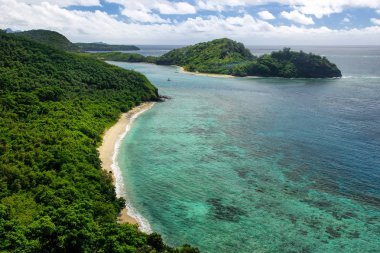 View of Drawaqa Island coastline and Nanuya Balavu Island, Yasawa Islands, Fiji. This archipelago consists of about 20 volcanic islands clipart