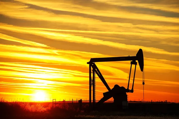 Prise de pompe dans le champ pétrolifère au coucher du soleil — Photo