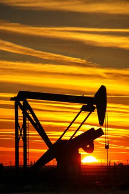 Gün batımında yağ sahasında Pompa jakı