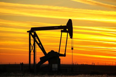 Gün batımında yağ sahasında Pompa jakı