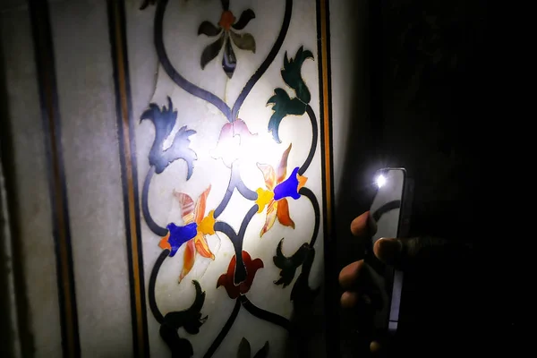 Tourist shining light on pietra dura (stone inlay) inside Taj Ma — Stock Photo, Image