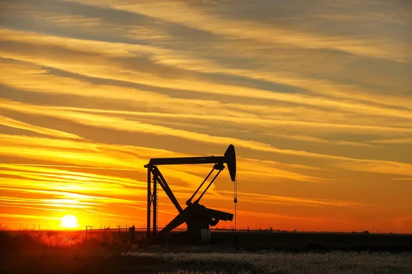 Prise de pompe dans le champ pétrolifère au coucher du soleil — Photo