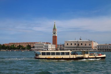 Vaporetto (su otobüsü) Venedik, İtalya 'da Piazza San Marco' nun önüne gidiyor. Venedik, 117 küçük adadan oluşan kanallarla ayrılmış ve köprülerle birbirine bağlı bir gruptur..
