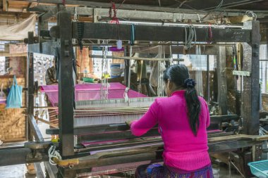 MANDALAY, MYANMAR - 28 Aralık 2016: Thein Nyo ipek dokuma fabrikasında çalışan kadın. Mandalay yüzyıllardır ipek üretiminin merkezidir.. 