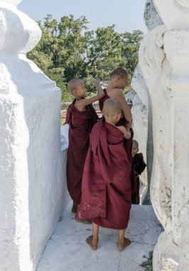Mingun, Myanmar - 28 Aralık 2016: Myanmar 'da Mandalay yakınlarındaki Mingun' daki Hsinbyume Myatheindan Pagoda 'da (Beyaz Tapınak) genç rahipler)