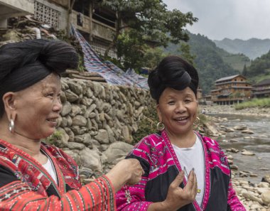 LONGJI, Çin - 4 Ağustos 2017: Kimliği belirsiz kadınlar Longji, Çin 'de saç fırçası ve stili. Çin 'in Longji Yao köyünde yaşayan Kızıl Yao kadınları dünyanın en uzun saçlarından birine sahipler..