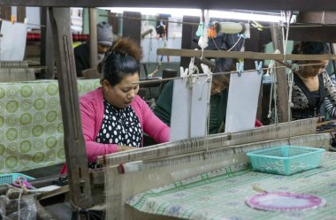 MANDALAY, MYANMAR - 28 Aralık 2016: Thein Nyo ipek dokuma fabrikasında çalışan kadın. Mandalay yüzyıllardır ipek üretiminin merkezidir.. 