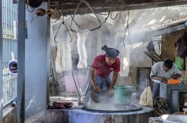 MANDALAY, MYANMAR - 28 Aralık 2016: Thein Nyo ipek dokuma fabrikasında çalışan kadın. Mandalay yüzyıllardır ipek üretiminin merkezidir.. 