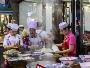 XIAN, ÇİN -1 AĞUSTOS 2017 - Beiyuanmen Müslüman Pazarı olarak da bilinen Xi 'an' ın Müslüman Mahallesi 'nde erişte üretip satan sokak yiyecek satıcılarının gece görüşü.