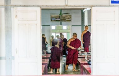 AMARAPURA, MYANMAR - 28 Aralık 2016: Mahagandayon manastırında yaşayan keşişler Amarapura, Mandalay Bölgesi, Myanmar 'daki bağışçılardan yiyecek almak için ortaya çıktılar.