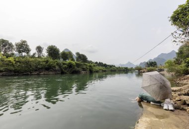 Yangsuo, Çin - 2 Ağustos 2017: Yangshuo, Guangxi, Çin 'deki Yulong nehri üzerindeki ejderha köprüsündeki kadın