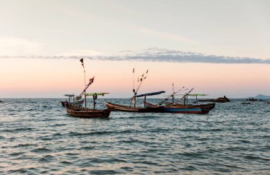 Gün batımında Ngapali 'nin kumlu plajı. Palmiye ağaçlarıyla süslenmiş beyaz kumlarıyla Bengal Körfezi 'nin berrak suları Myanmar' ın en önemli plajı olarak haklı bir üne sahiptir..
