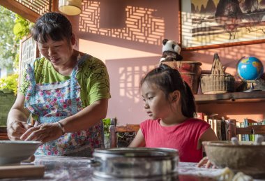 Yangshuo, Çin - 02 Ağustos 2017: Yangshuo, Çin yakınlarındaki Mountain Nest Otel 'de çocuklar erişte pişiriyor.