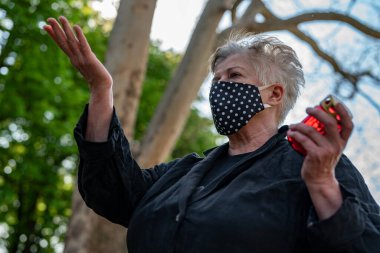 Mezarlık maskeli yaşlı kadın.