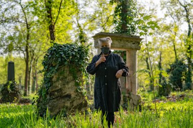 Mezarlık maskeli yaşlı kadın.