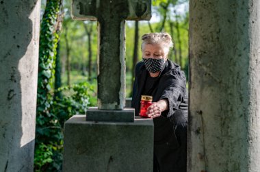 Mezarlık maskeli yaşlı kadın.