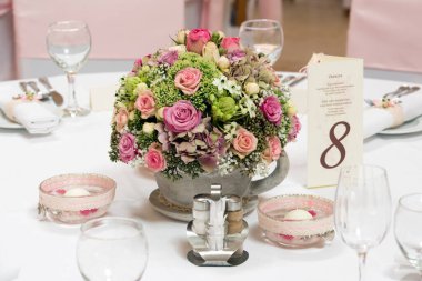 Çiçekli ve gözlüklü düğün masası.