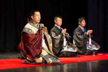 Kimonolu iki genç ve arka planda kitap olan bir kravat.