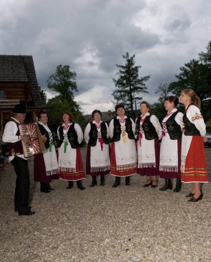 BESKIDES, POLAND - 10 Temmuz 2009 'da geleneksel giyinmiş folklor grubu Polonya' nın Beskides milli parkında bir tarım merkezinde ilk kez sahneye çıktı..