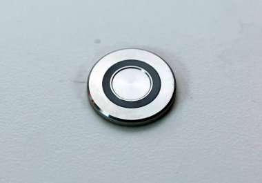 Gri arkaplanda metal bir düğmeyi kapat