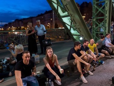 Budapeşte, Macaristan - 6 Temmuz 2019: Macar başkentinin en eski köprülerinden biri olan Liberty Köprüsü 'nde yaz gecesinin tadını çıkaran tanımlanamayan insanlar. Köprü hafta sonları ulaşıma kapatıldı. 