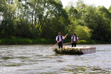Dunajec nehrinde teknesi olan şapkalı bir adam.