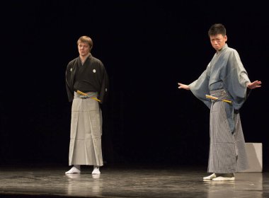 Kimliği belirsiz insanlar Japon tarzında tiyatro sahnelerinde oynuyorlar.