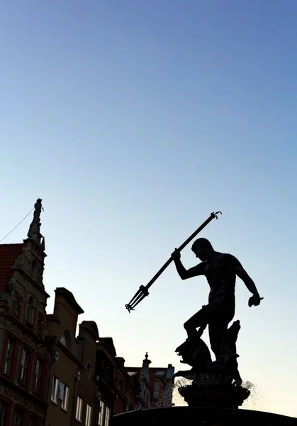 青い空を背景に剣を持った黒いスーツの男のシルエット — ストック写真
